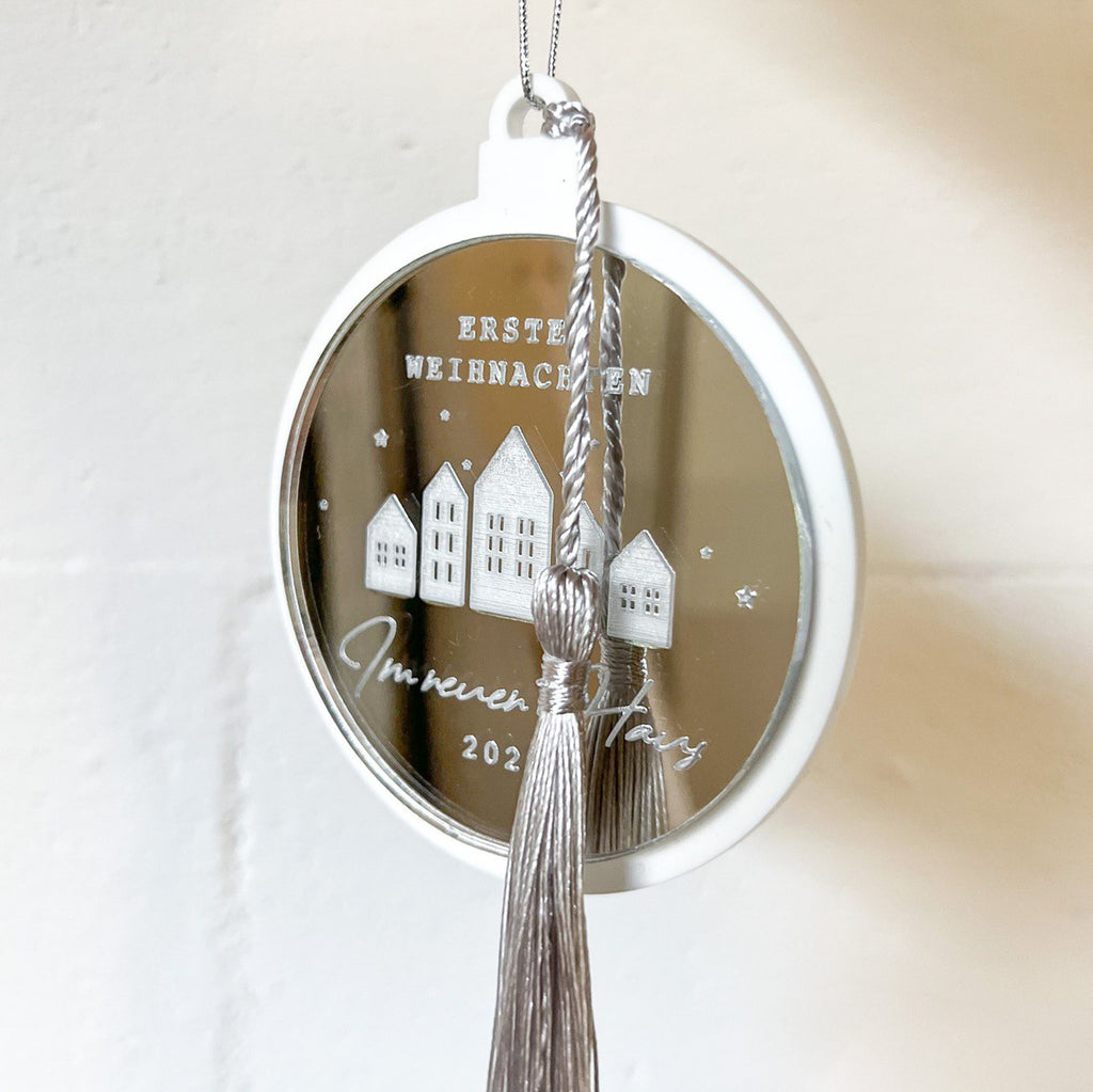 Personalisierte Christbaumkugel mit Namen, festlich am Tannenbaum angebracht