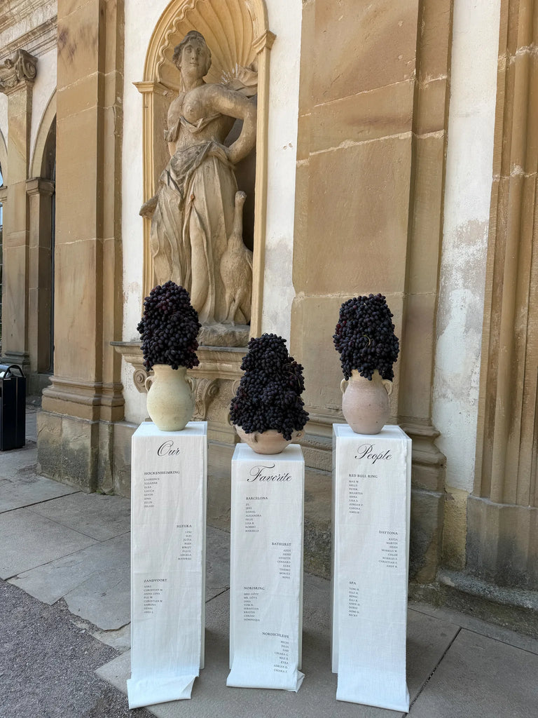 Gesamtansicht des Leinen-Sitzplans mit Statue im Hintergrund, arrangiert für eine Hochzeitsfeier an einem Schloss.