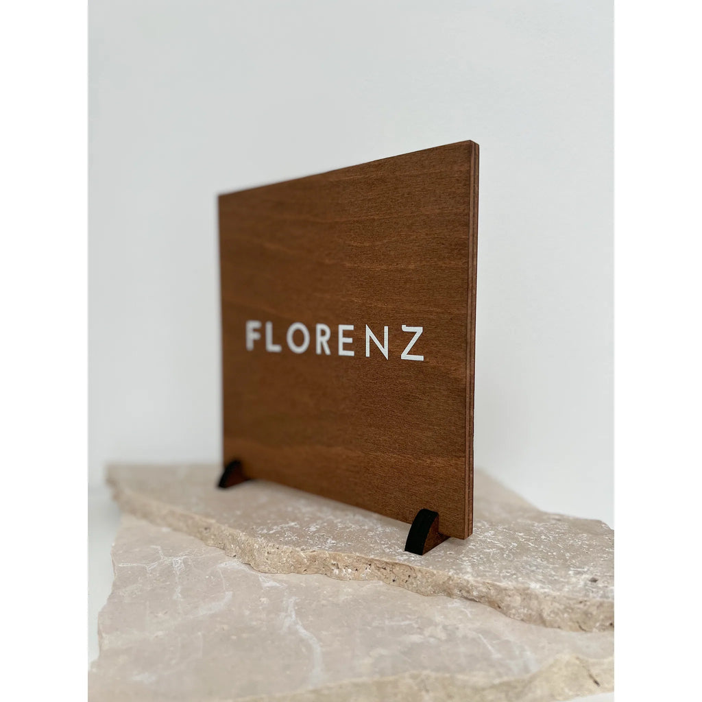 Seitliche Ansicht einer Tischnummer aus Buchenholz mit Aufdruck Florenz, die schlanke Materialstärke und der kleine Holzfuß sind gut erkennbar.