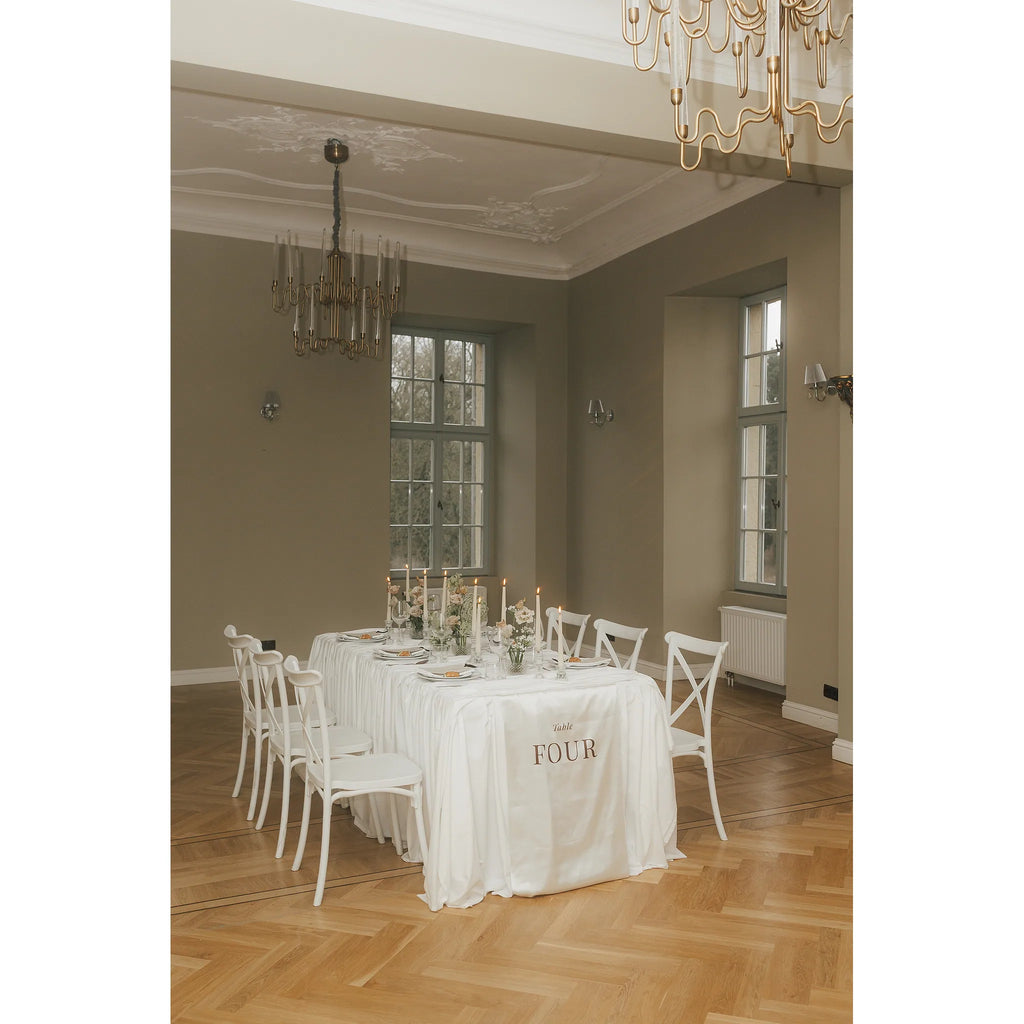 Close-up des Aufdrucks Table Four auf hellem Stoff mit weichem Schattenwurf