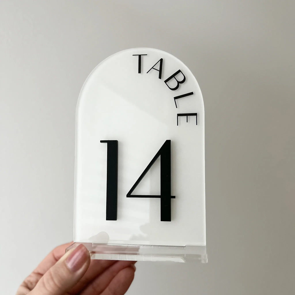 Detailansicht der weißen Tischnummer 6 mit transparentem Acrylfuß auf weißer Tischdecke.